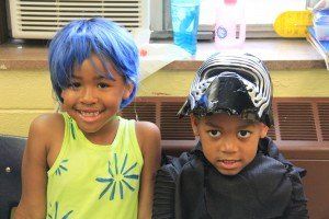 A boy and a girl are sitting next to each other wearing costumes.