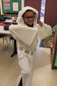 A young girl is dressed as princess leia from star wars in a classroom.