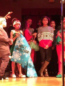 A group of people standing on a stage holding a sign that says family mistletoe