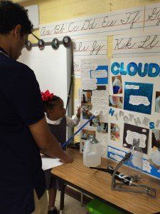 A man and a little girl are standing in front of a white board with the word cloud on it.