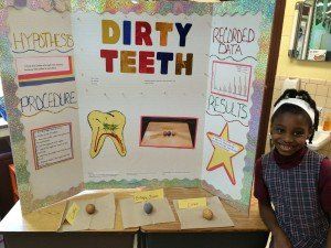 A girl is standing in front of a poster that says dirty teeth
