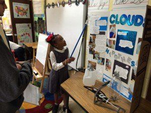 A girl is standing in front of a poster that says cloud