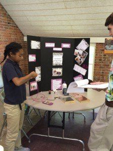 A man and a girl are standing in front of a table.