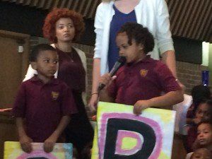 A girl is holding a sign with the letter p on it