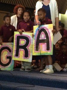 A group of children holding signs that say gra