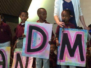 A group of children holding up signs that say dm
