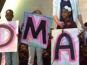 A group of children are holding up signs that say dma