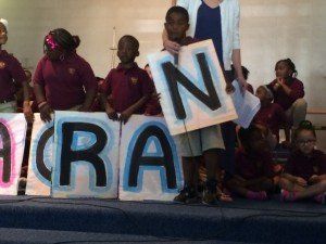 A group of children are holding signs that say aran