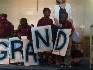 A group of children holding signs that say grand