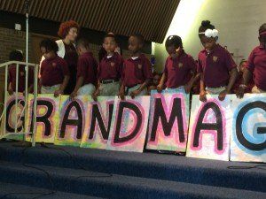 A group of children holding signs that say grandmag