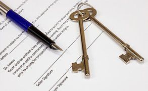 A large set of keys and a fountain pen resting on a document