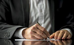 A man signing a document 