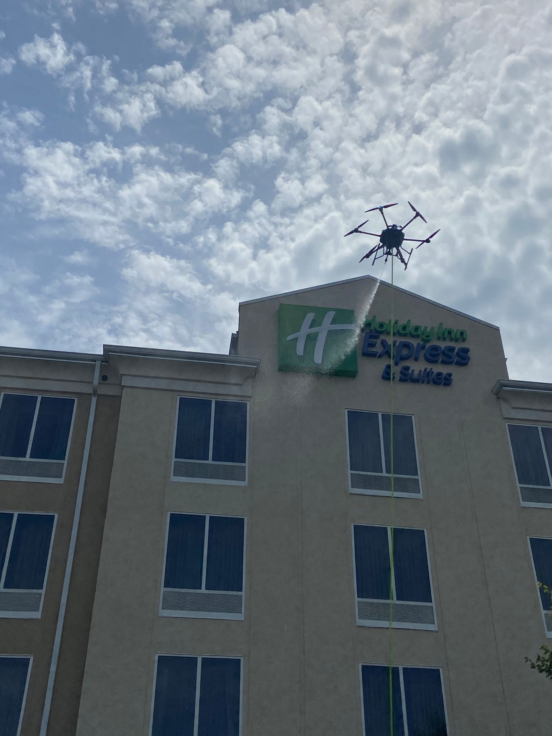A logo for chicagoland drone wash with a drone flying over a city