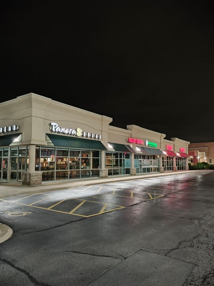 A panera restaurant is lit up at night