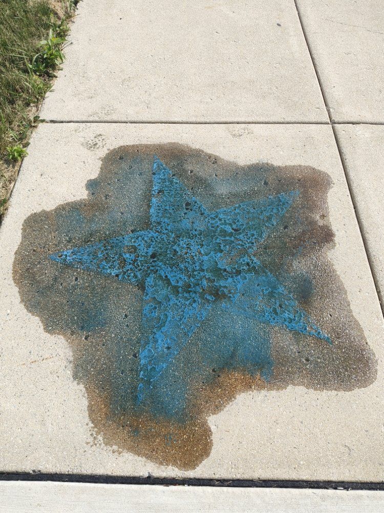 A blue starfish is painted on the sidewalk.