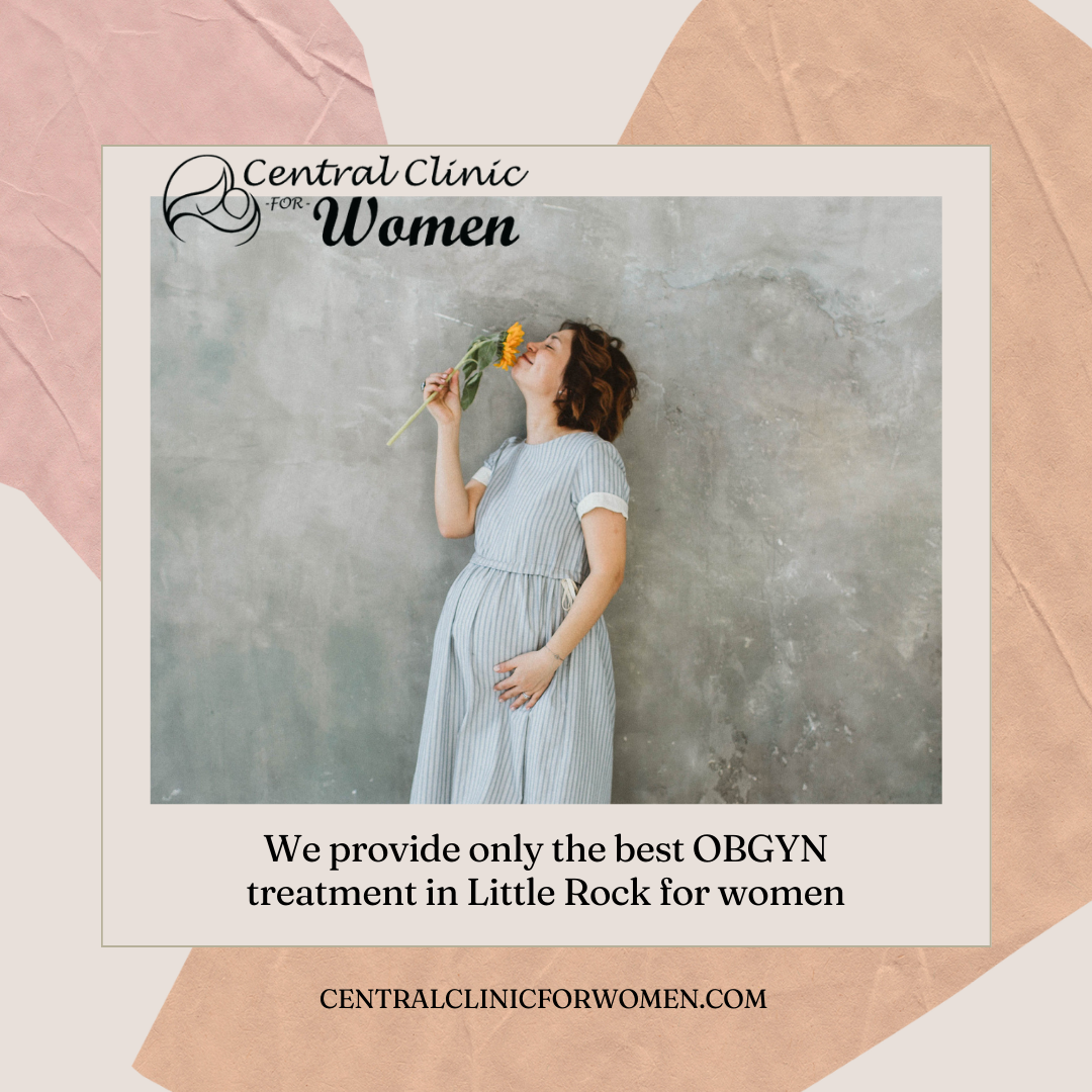 A pregnant woman is holding a flower in her mouth.