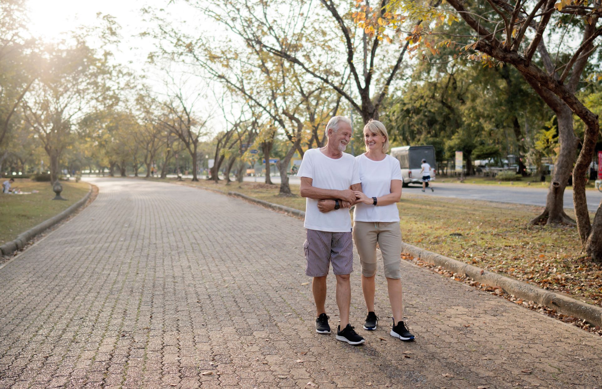 A man and a woman are standing next to each other on a sidewalk.