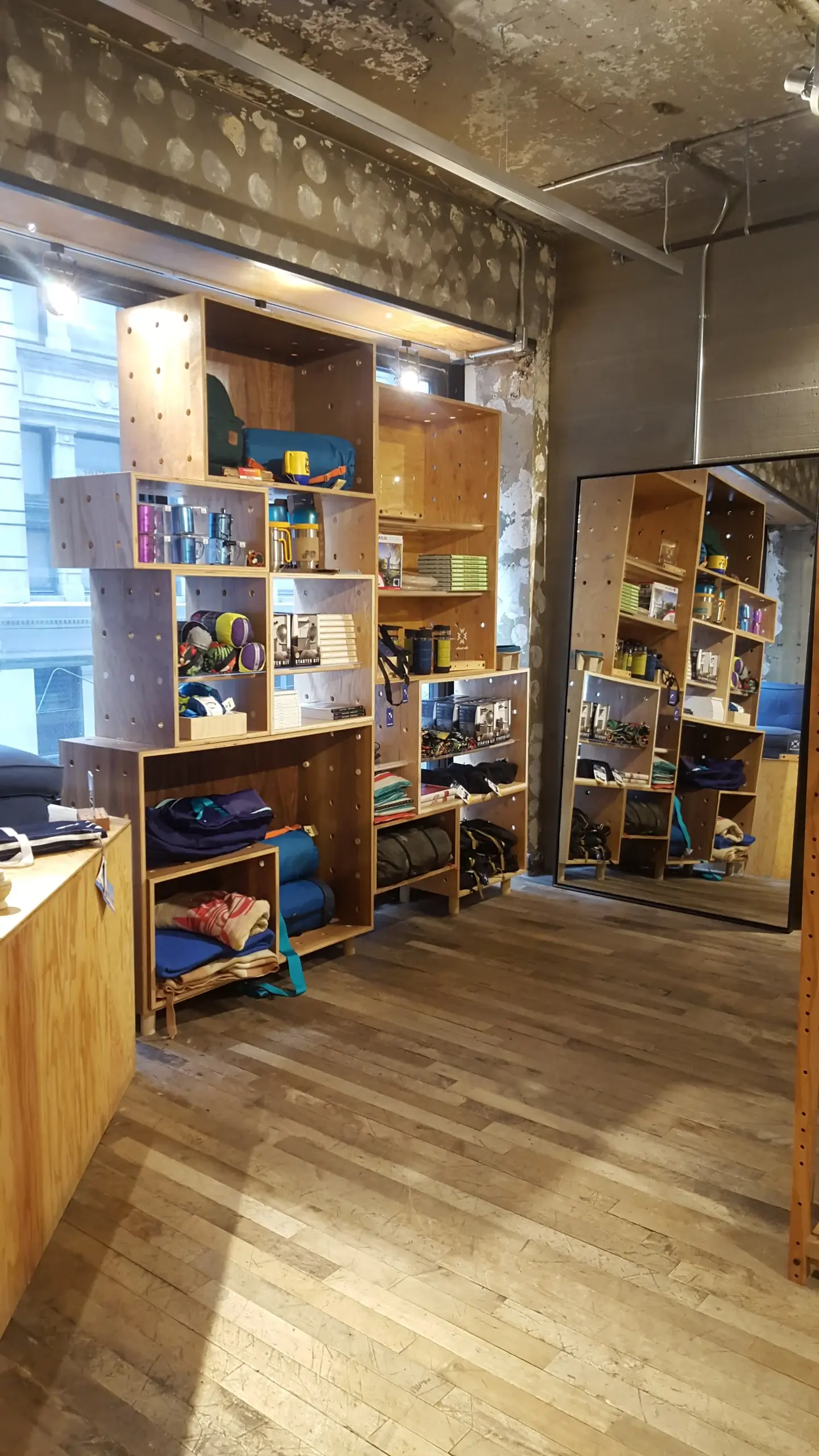 A room with a lot of shelves and a mirror.