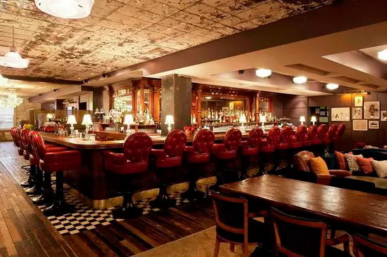 A restaurant with a long bar and tables and chairs