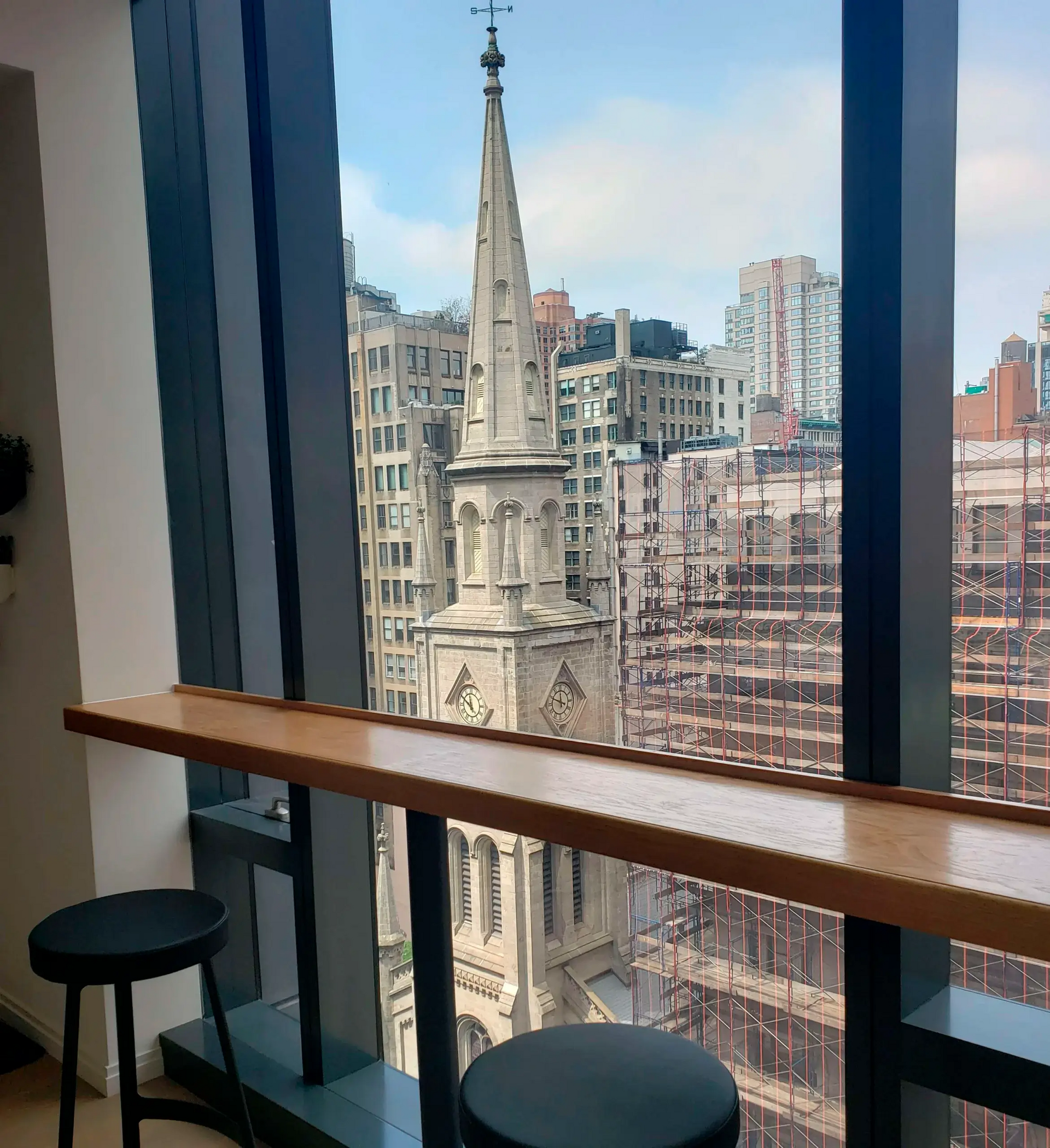 A view of a city from a window with a clock tower in the background