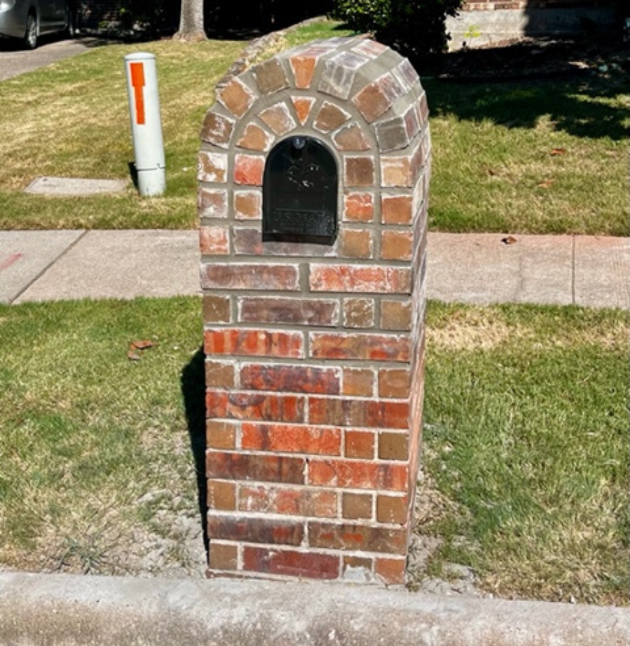 A brick mailbox on the side of the road