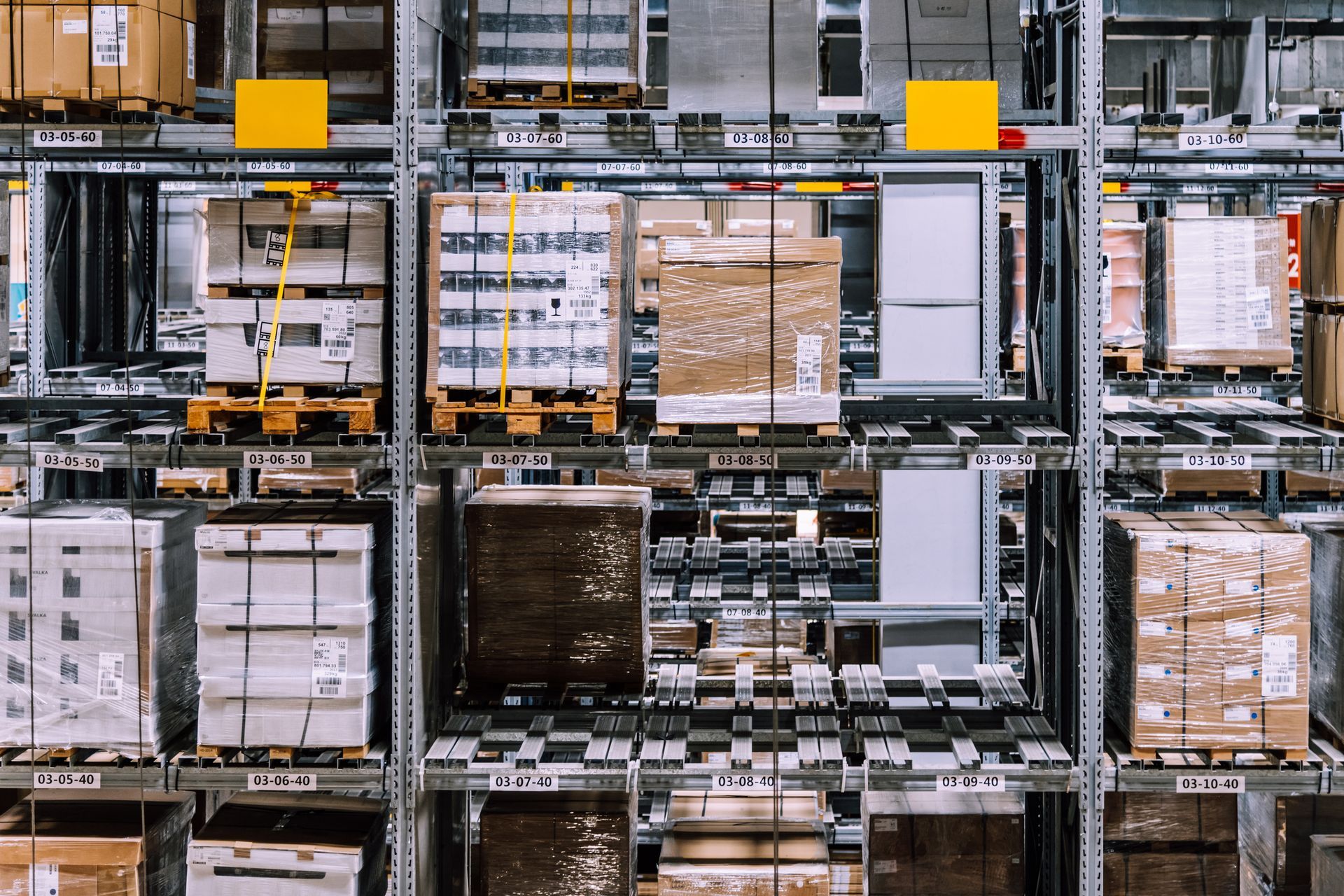 Warehouse shelving filled with packaged goods and pallets.
