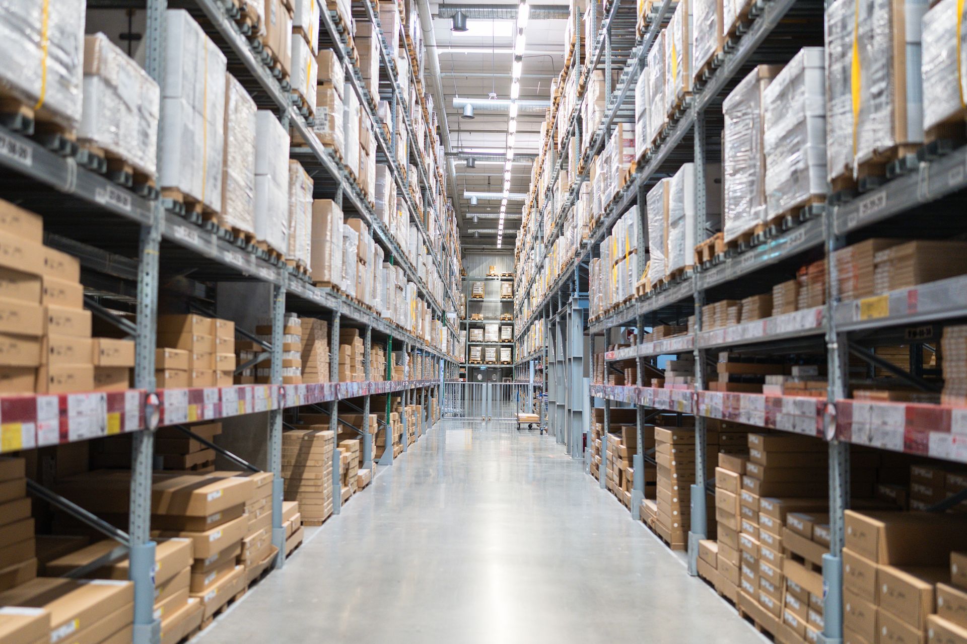 Warehouse aisle filled with boxes on tall metal shelves.