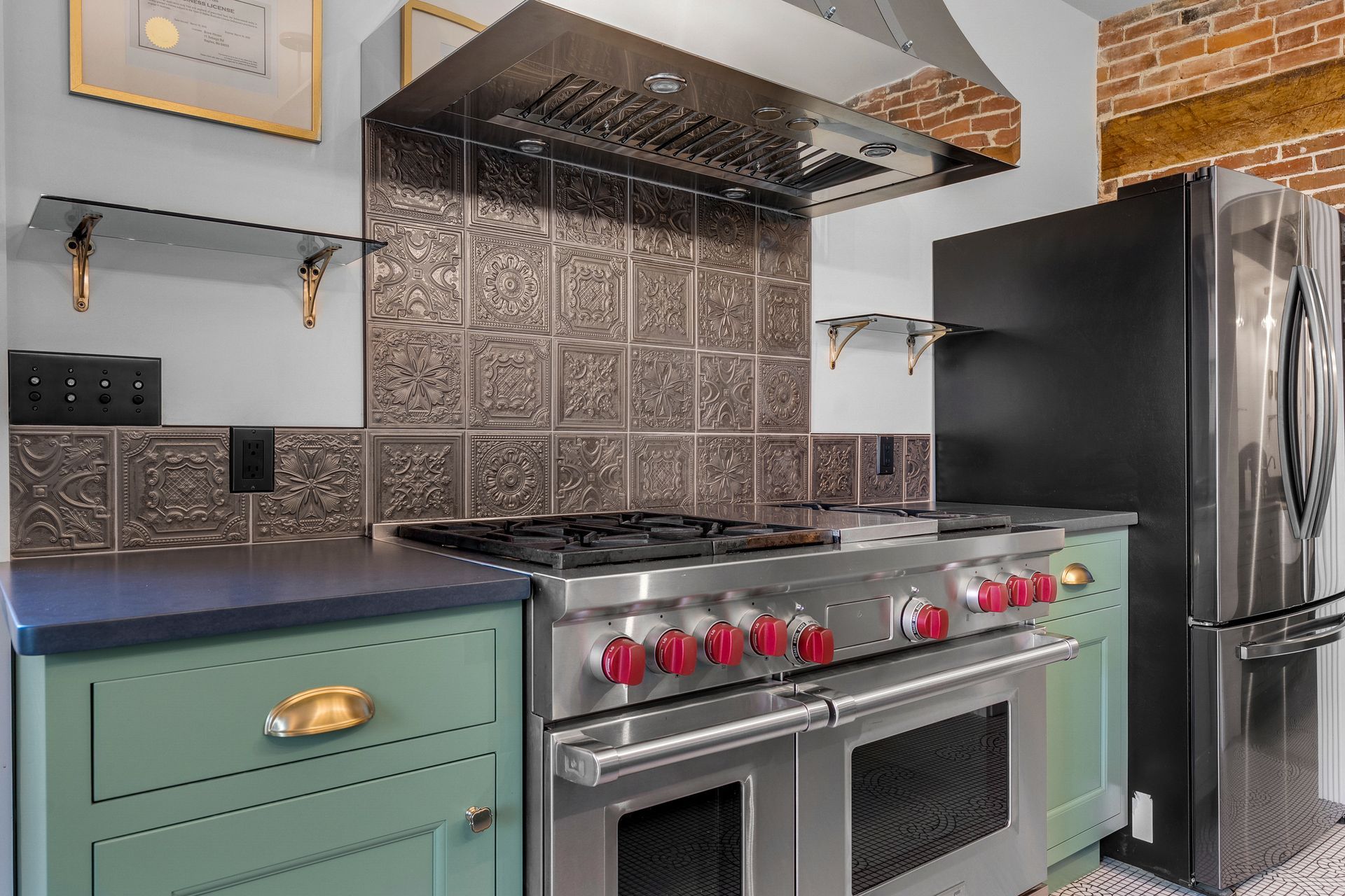 Kitchen with a stainless steel range, green cabinets, and a black refrigerator.