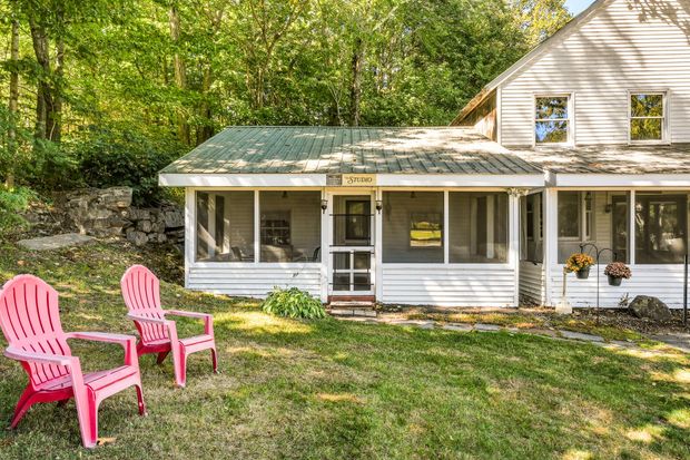 A sunset over a foggy mountain range with trees in the foreground.