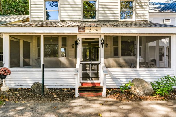 A sunset over a foggy mountain range with trees in the foreground.
