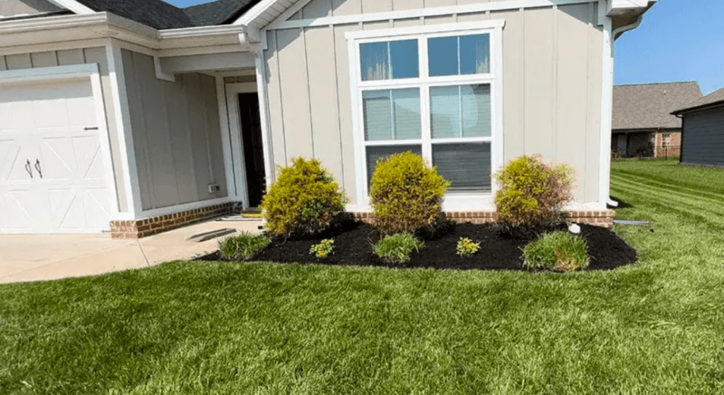 A house with a lush green lawn in front of it.