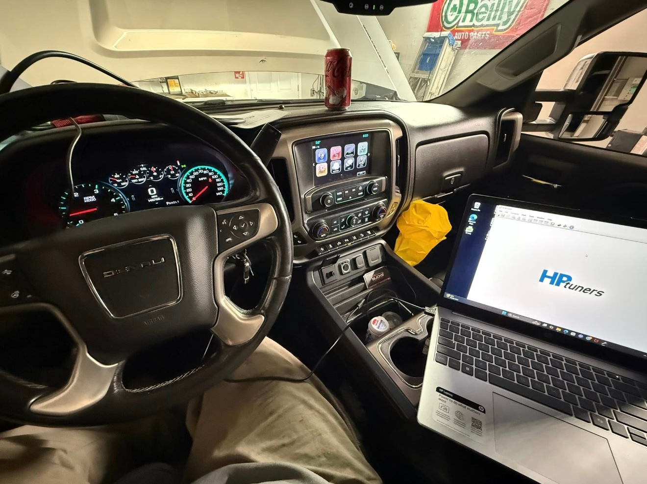 Interior of a truck with a laptop running HP Tuners software connected to the vehicle's diagnostic port. | Bucks Auto Garage & Tire