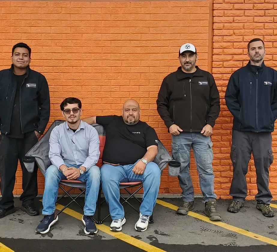 Our staff in front of our shop wall | Pinnacle Automotive