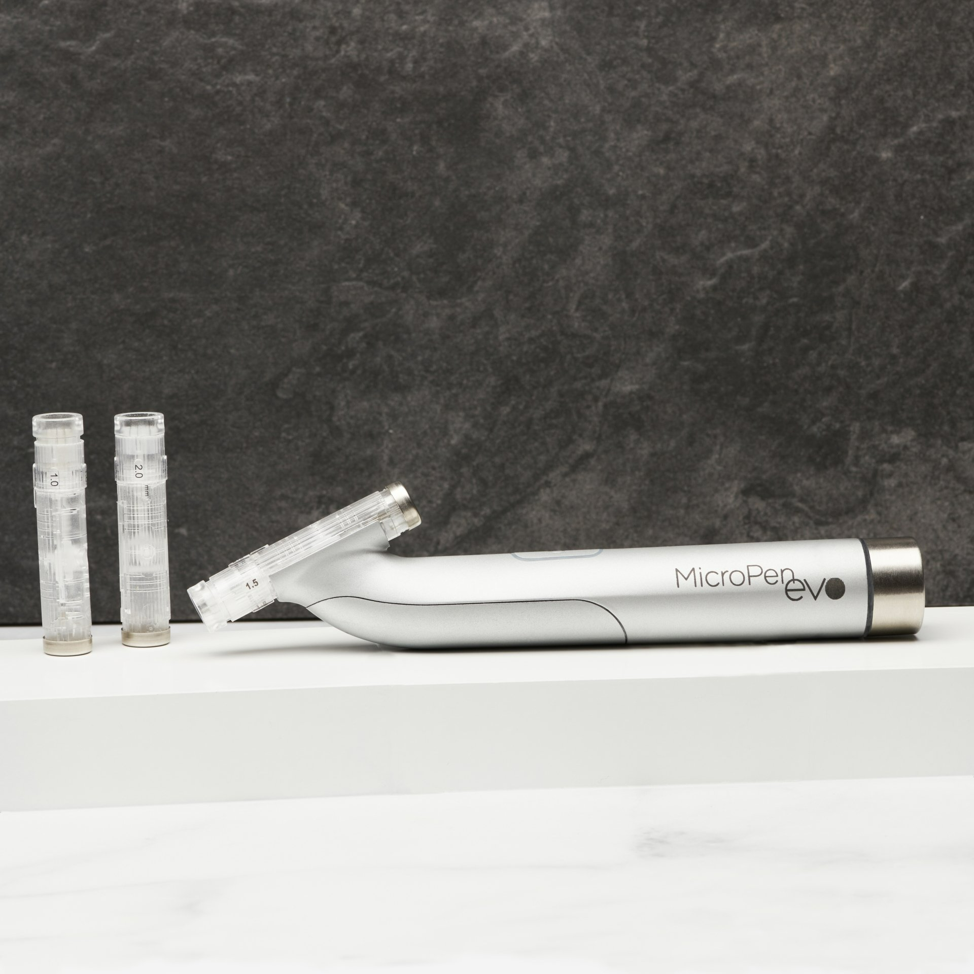 Close-up of Eclipse MicroPen EVO microneedling device with needle tip cartridges on a white surface