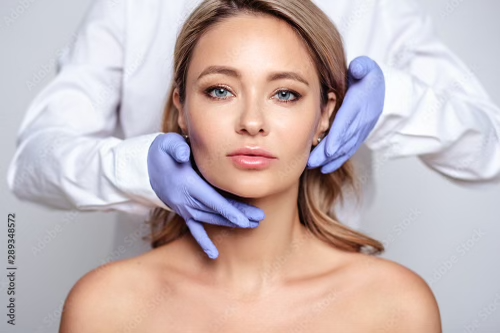 Medical provider examining woman’s skin before RF microneedling treatment for facial rejuvenation