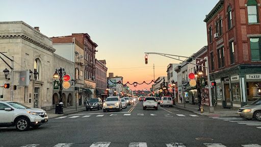 A busy city street with cars driving down it at sunset.