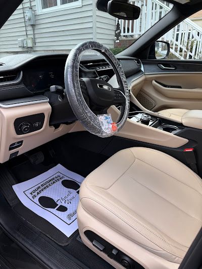 The inside of a car with a steering wheel wrapped in plastic.