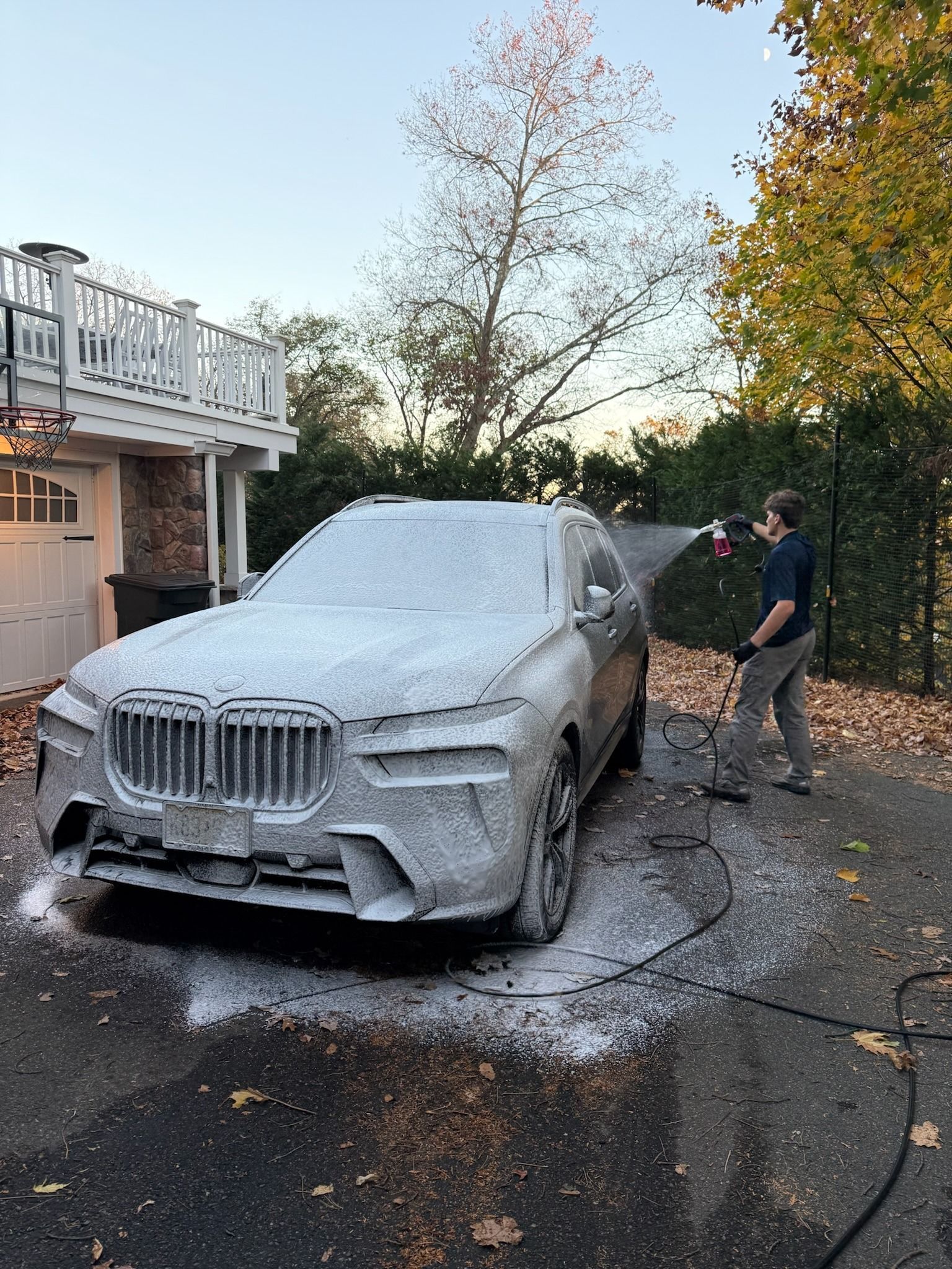 A car is being washed with foam in a garage.
