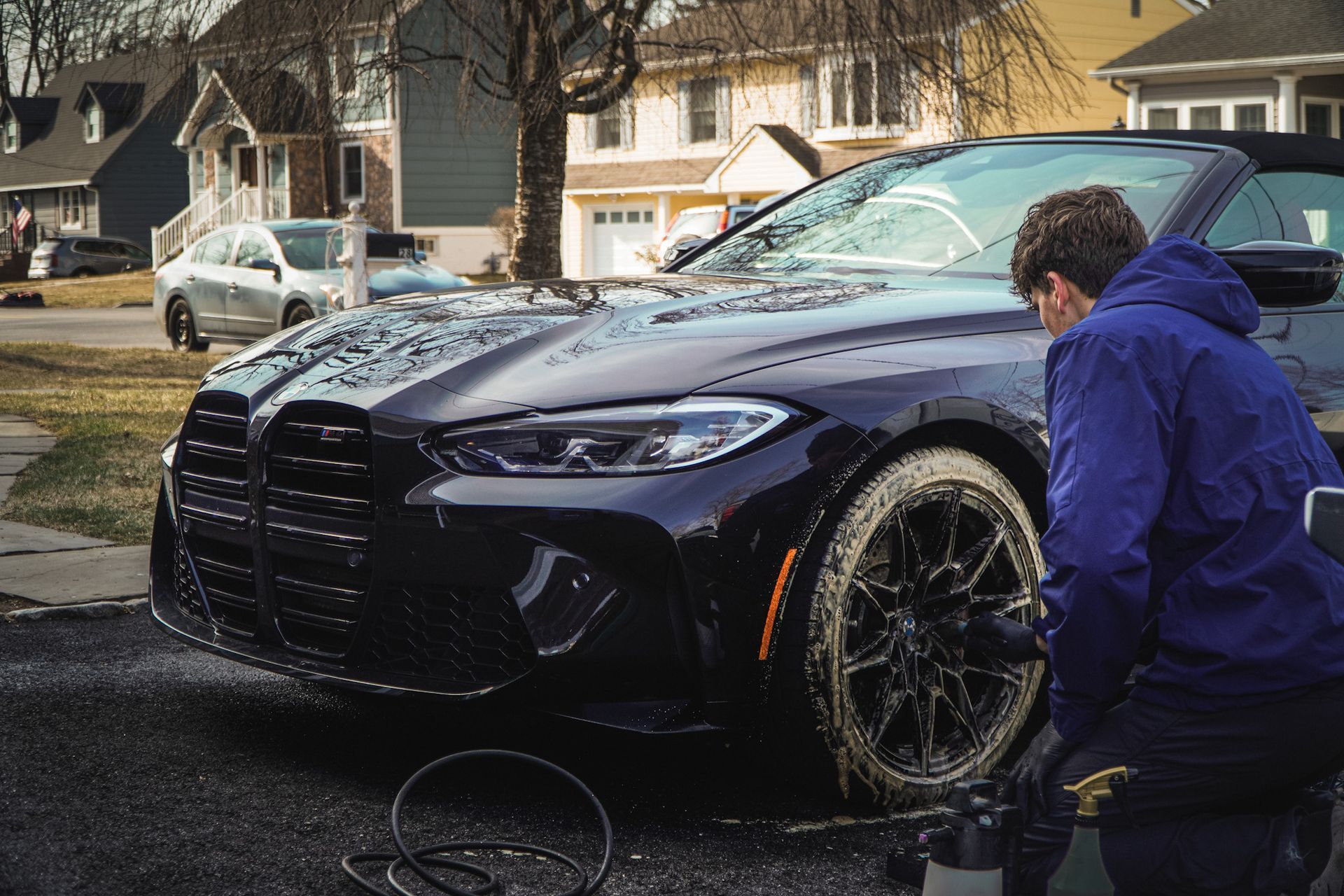 A person wearing black gloves is cleaning a car with a towel