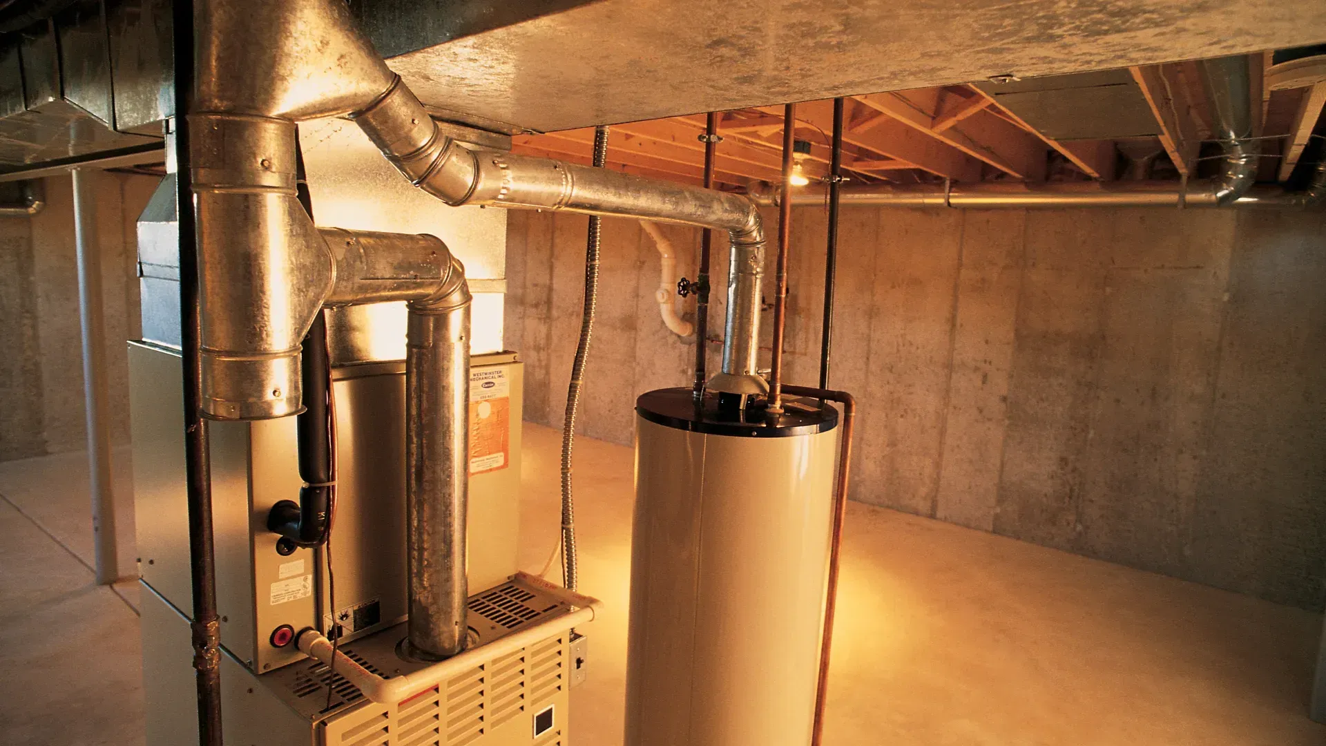 A basement with a heater and a water heater in it.