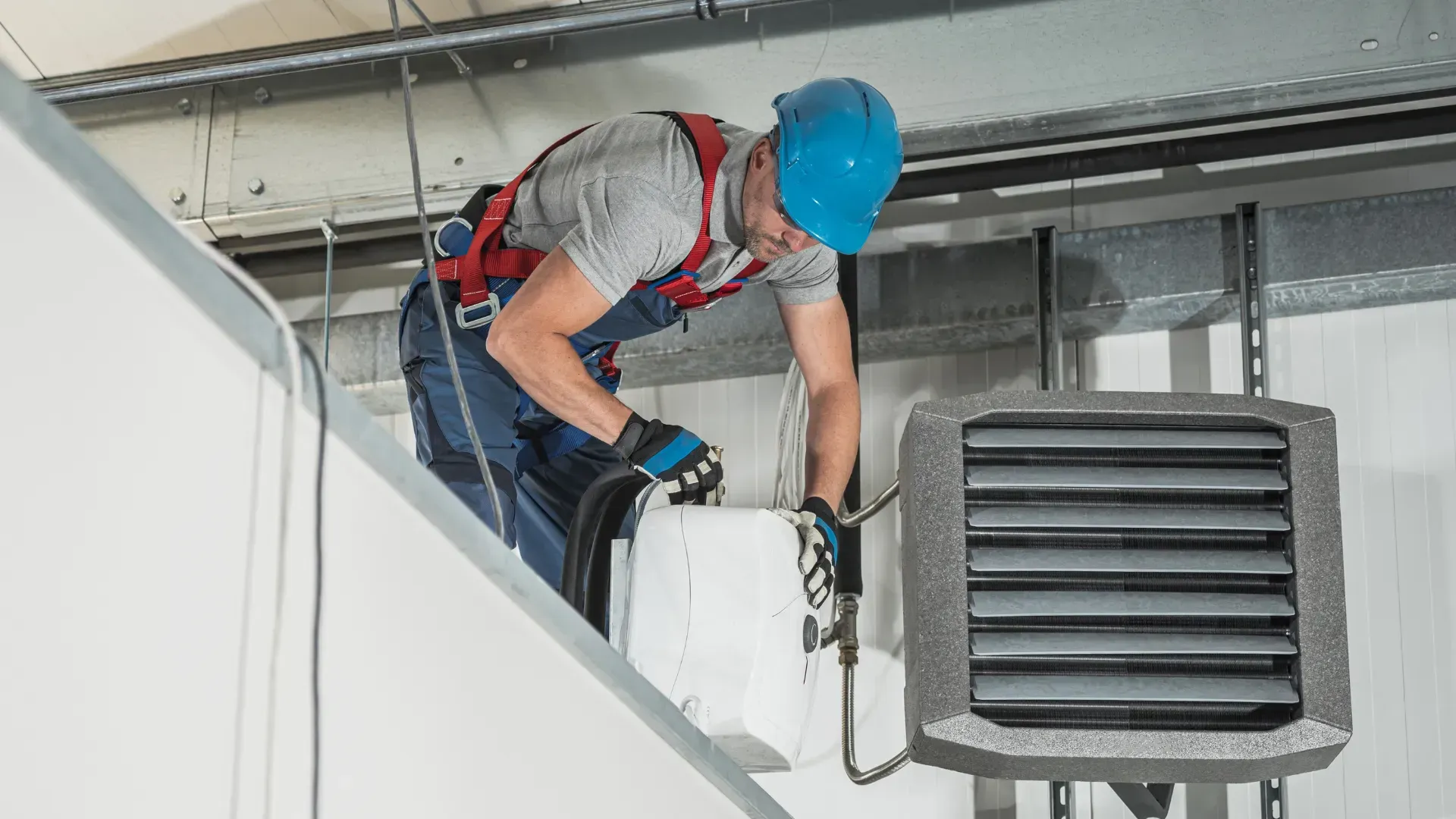 A man is working on a heater in a building.