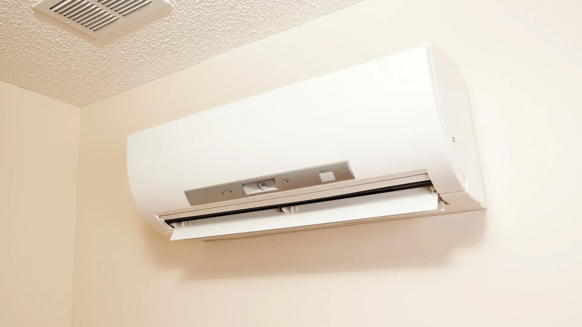 A white air conditioner is hanging on a wall in a room.