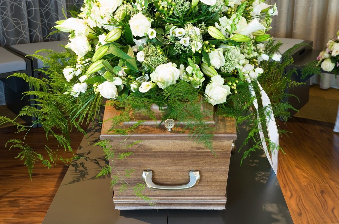 cassa funebre con copribara di fiori bianchi