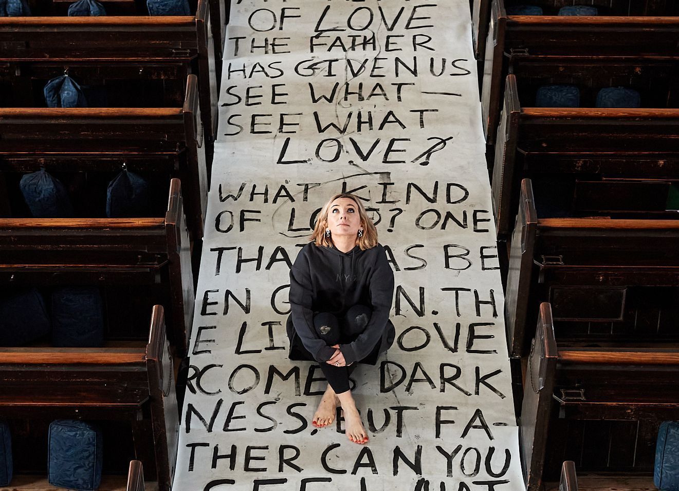 Jemima Sara sitting on artwork at St Georges Church