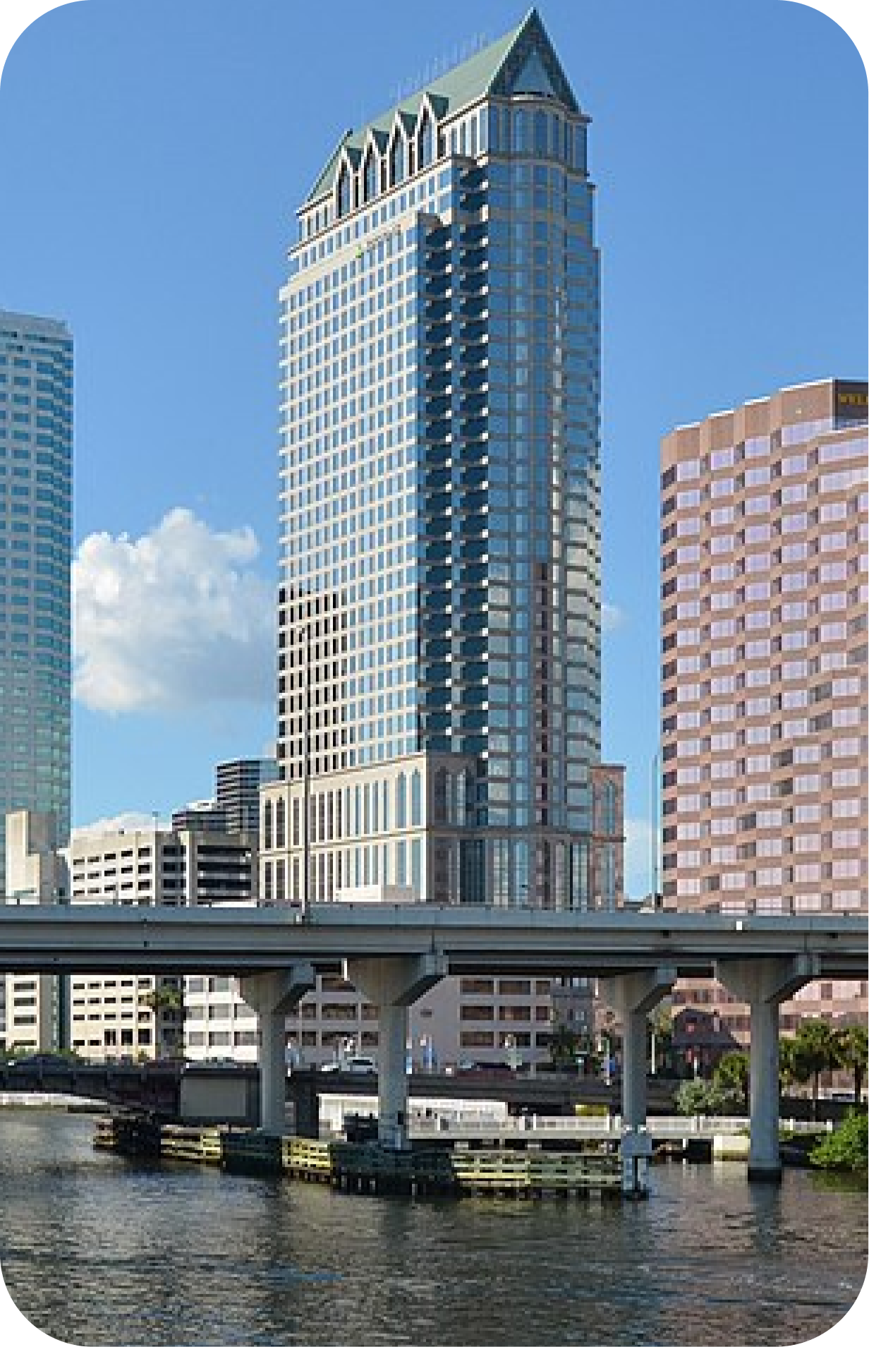 Two modern blue glass skyscrapers against a partly cloudy sky.