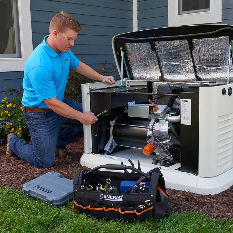 A man in a blue shirt is working on a generator