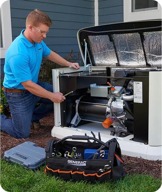 A man in a blue shirt is working on a generator