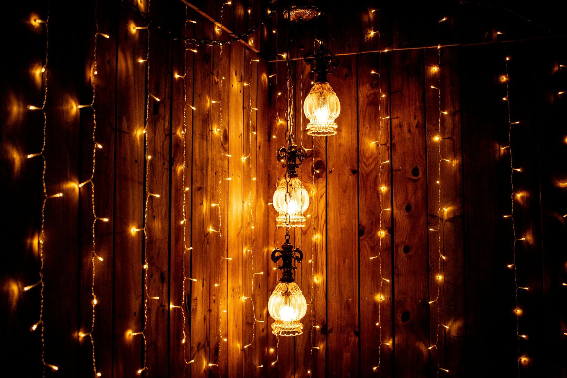 A wooden wall with a string of lights hanging from it.