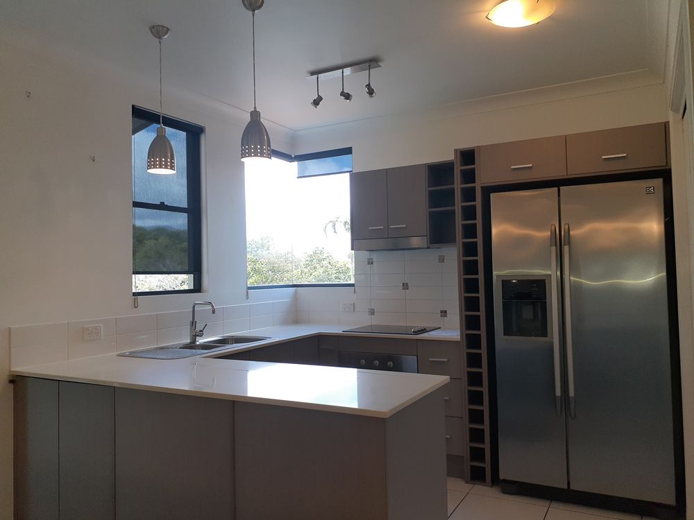 An Empty Kitchen with A Stainless Steel Refrigerator — Cairns Vacate Clean in Manunda, QLD