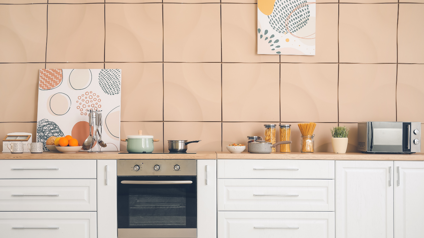 Kitchen with white cabinets, light countertops, and beige tiled backsplash. Includes appliances and decor.